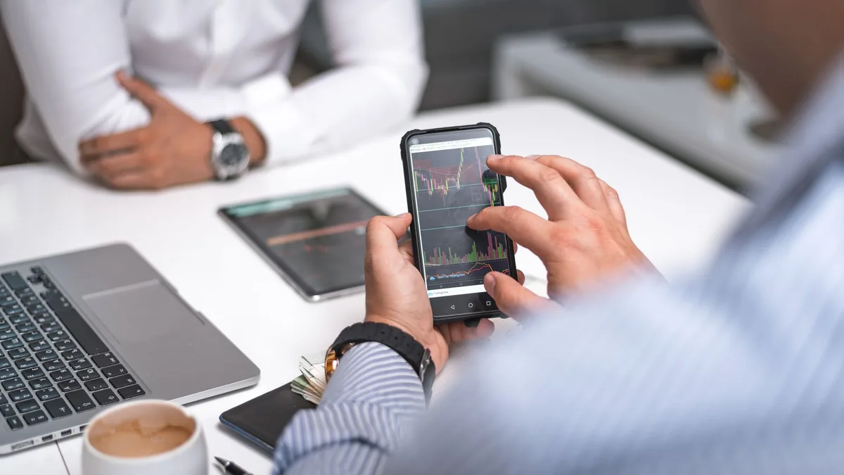 Professionisti che consultano dati aziendali su smartphone e laptop