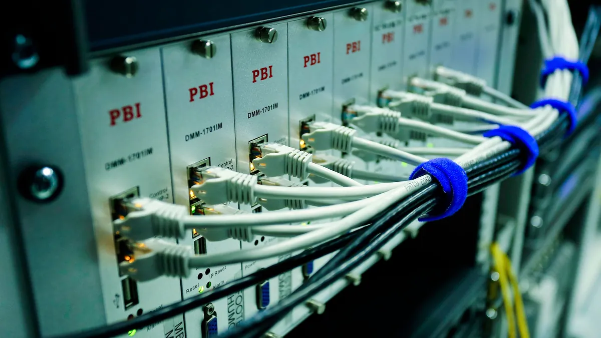 Tecnico che collega cavi in un armadio di rete per telecomunicazioni